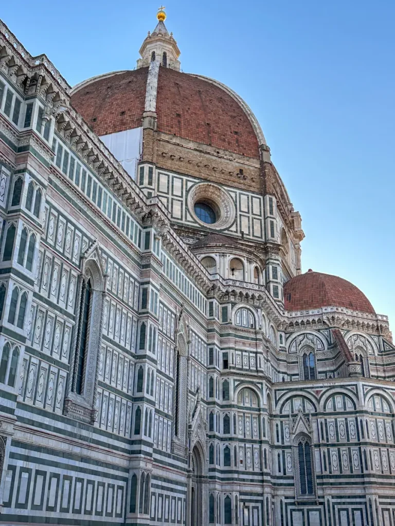 Detailed exterior of Florence Cathedral showing green and white marble patterns arches and ornate facade. The architecture highlights a must see landmark during a 3 days in Florence Italy itinerary