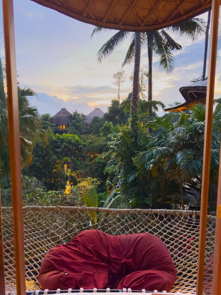 view of the nature from the Royal Duplex Pool Villa in the second floor with warm wooden details, hammock at sunset at The Udaya Resort Bali
