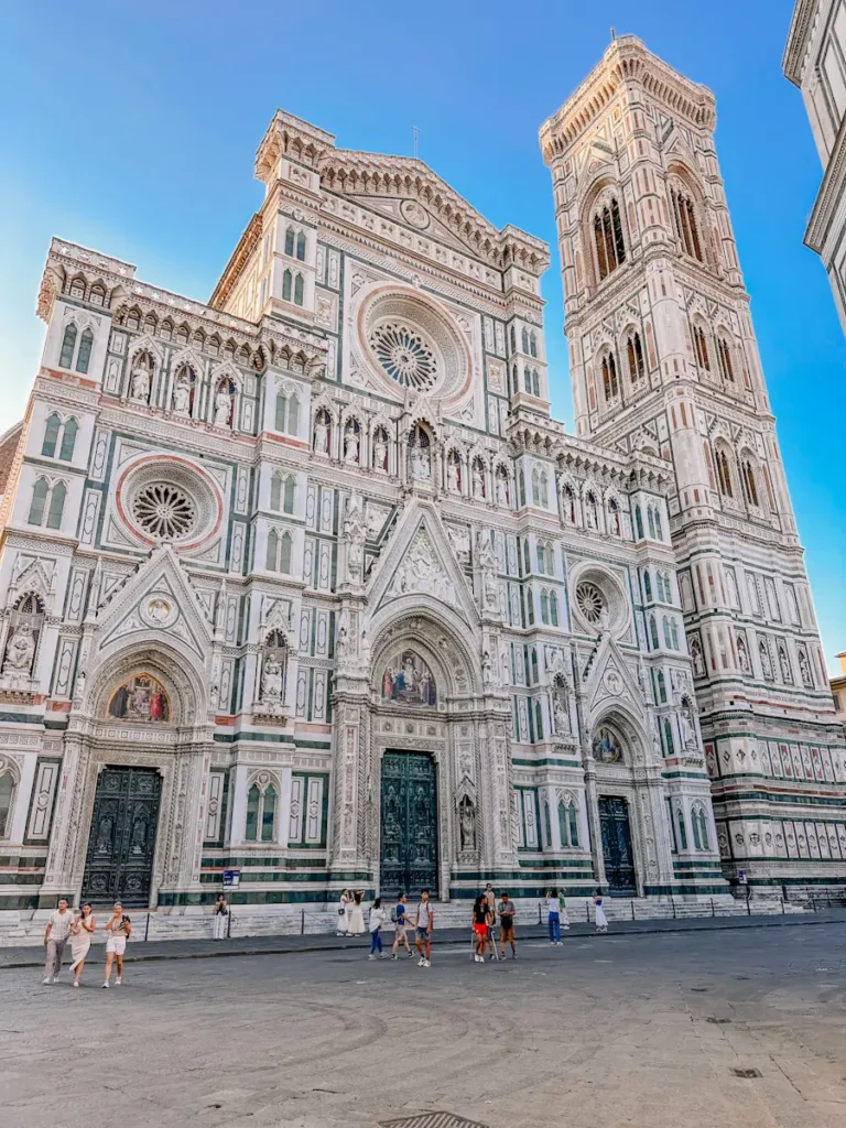 Wide view of Florence Cathedral in Florence Italy with its detailed marble facade and large open square in front. The landmark setting provides context for the central location of the stay.